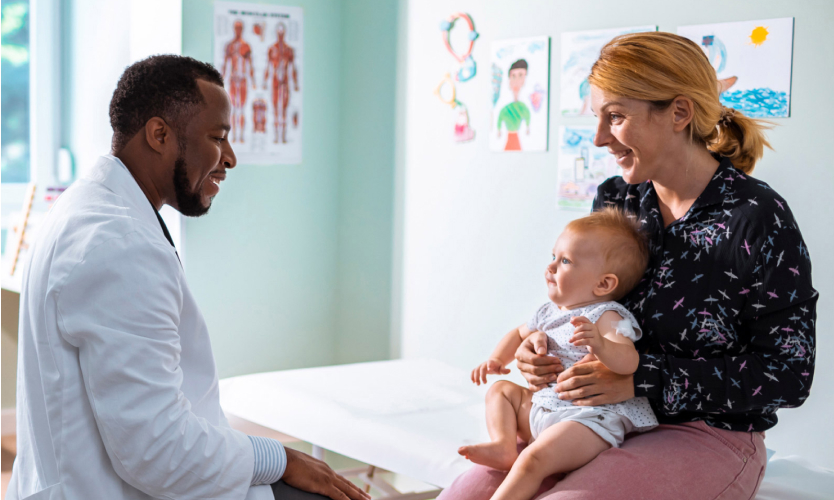 A doctor speaking to a mother with her baby