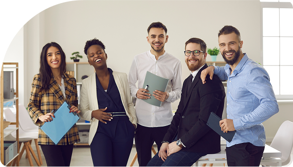 Group of smiling business owners and employees gathered around a computer, looking happy and engaged.