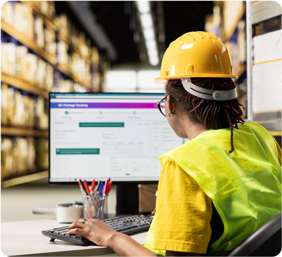 Warehouse worker in hard hat using free inventory tracking template on their computer