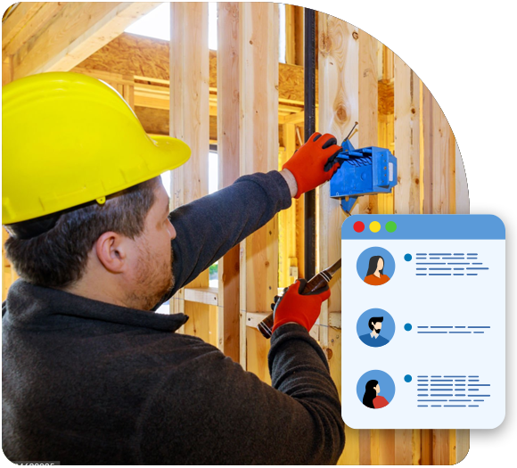 Male electrician with a yellow hard hat working on electrical wiring on the internal wood frame of a home