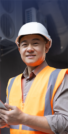 HVAC technician wearing safety gear and inspecting ventilation or mechanical equipment.