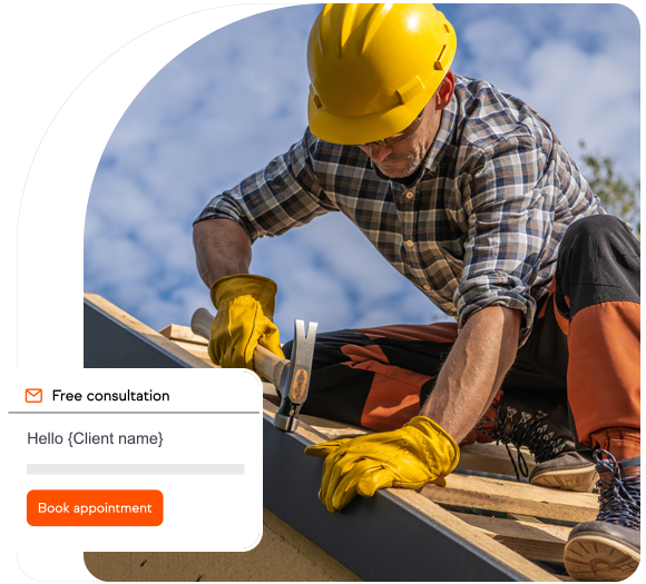 Roofer with a yellow hard hat on the roof hammering nails into wood