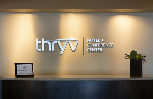 Desk with Thryv Hotel & Conference Center printed on the wall